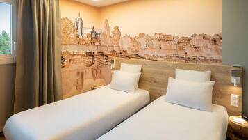 Een hotelkamer met twee bedden, een stadsgezicht muurschildering en een raam met gordijnen.