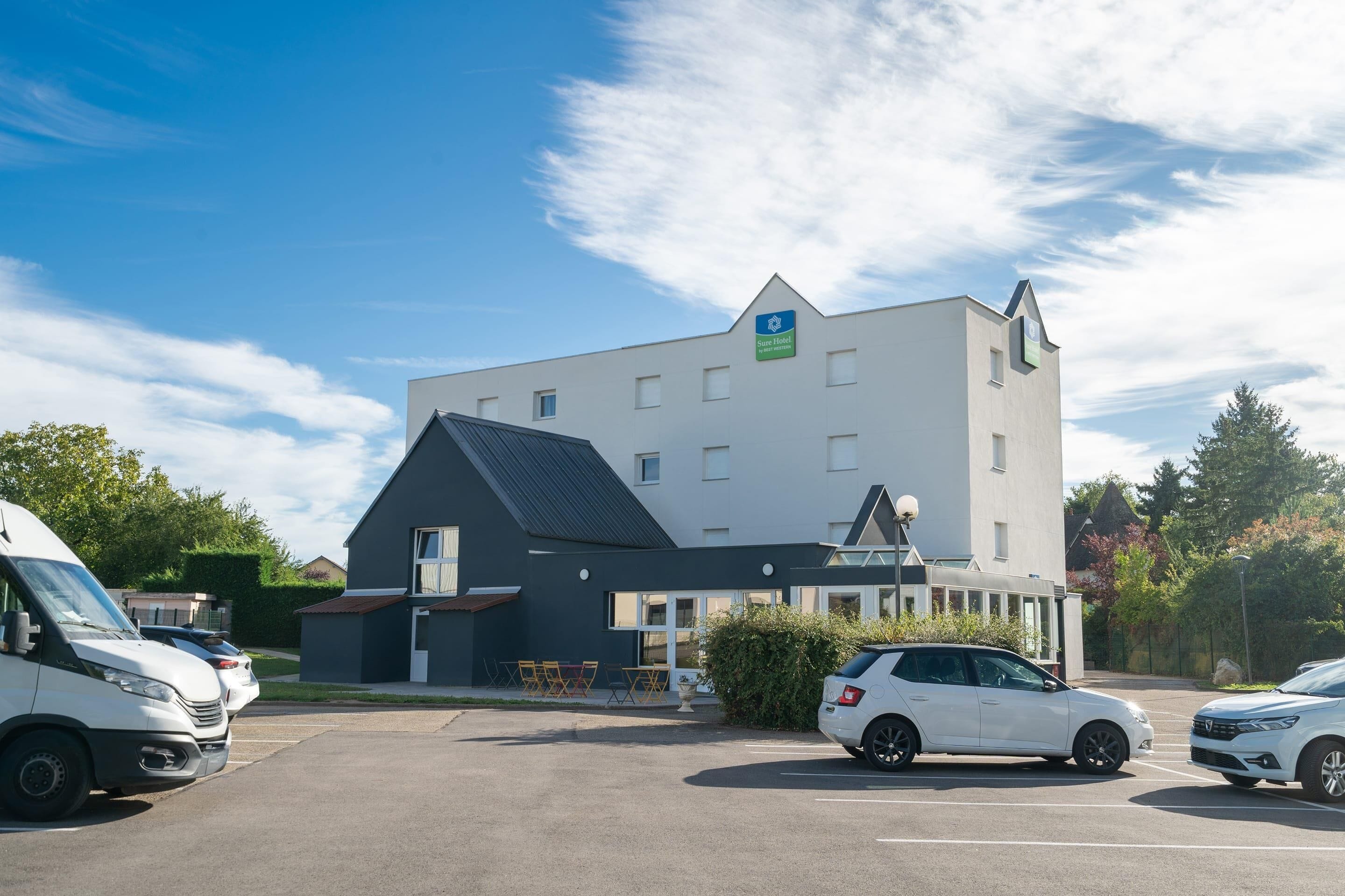 Un hotel moderno con techo plano, múltiples ventanas y un cartel que indica que es un Holiday Inn Express.