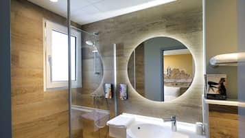 A modern bathroom with a glass-enclosed shower, a large mirror, and a wooden wall.