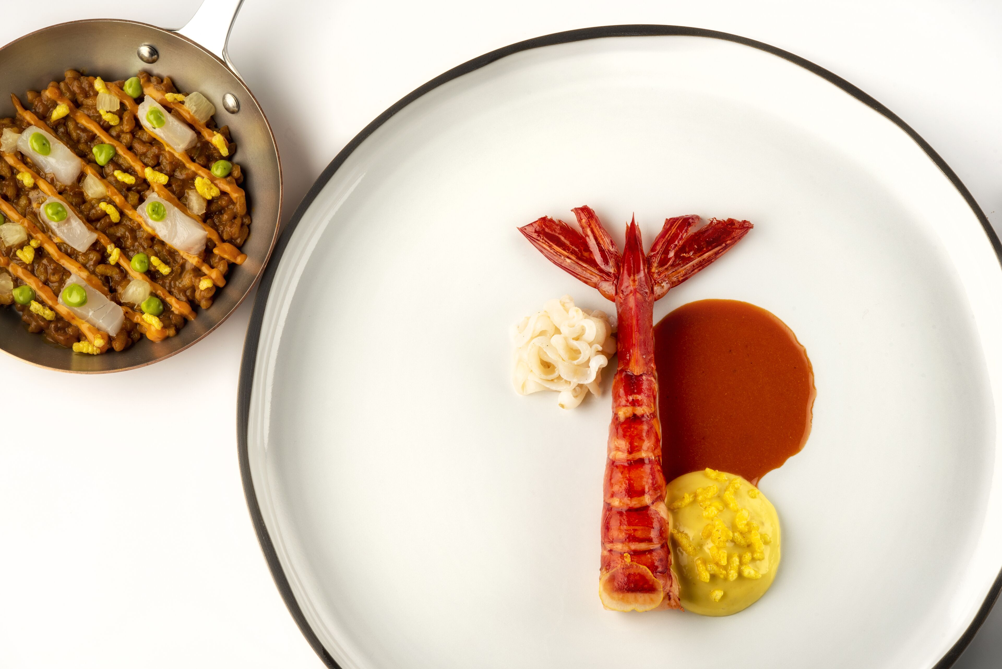 A plate with a piece of meat, a dollop of sauce, and a small bowl of sauce.