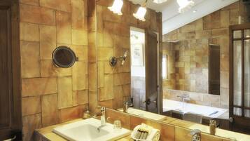 Une salle de bain avec un grand miroir, deux lavabos et un porte-serviettes.