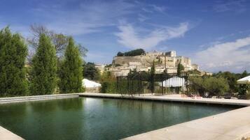 Una piscina al aire libre, sillones reclinables de piscina