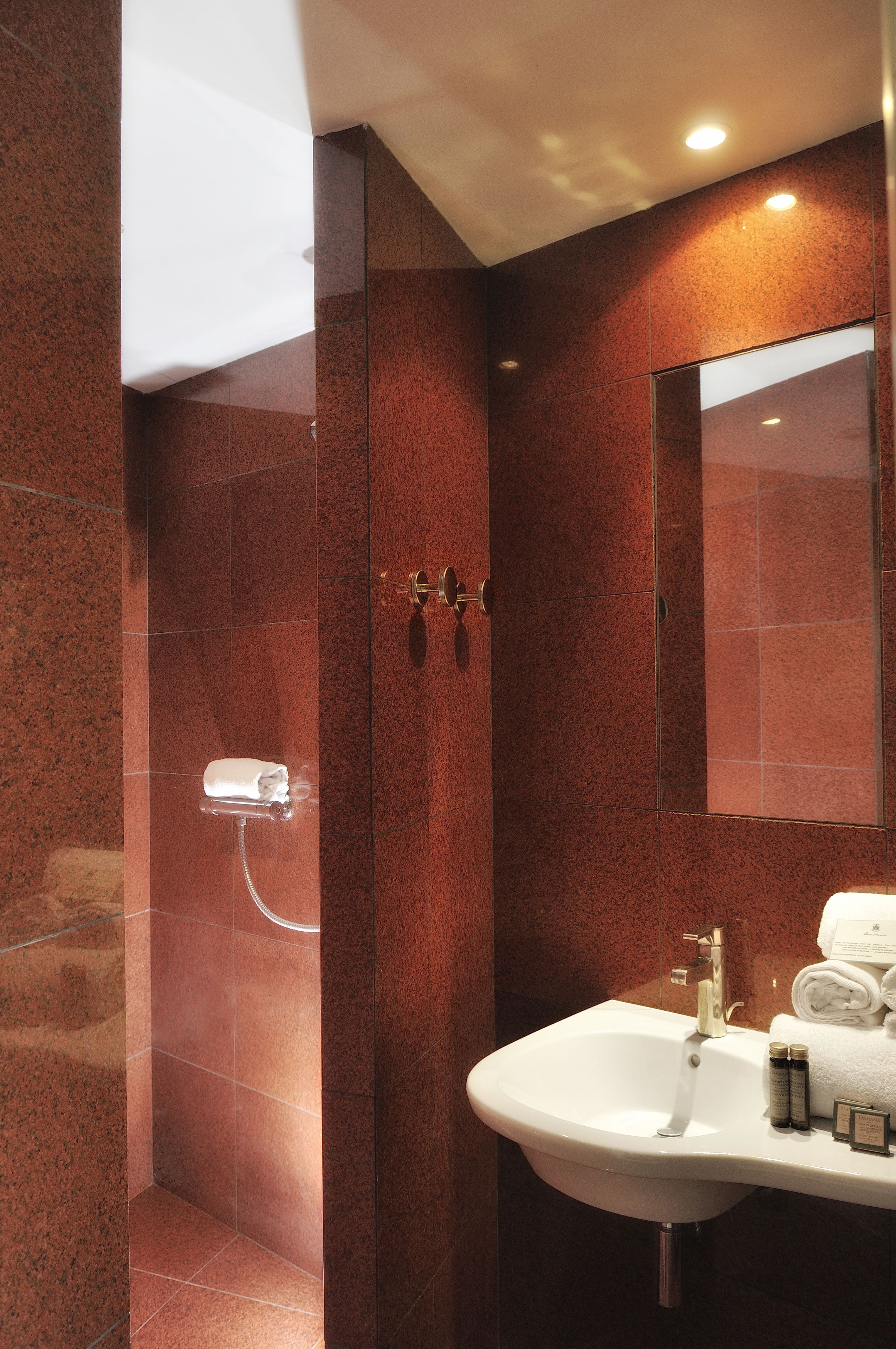 A modern bathroom with a marble wall, a sink, and a mirror.
