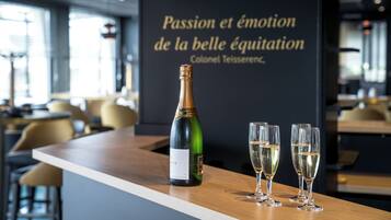 Un coin bar avec une bouteille de champagne et trois verres posés sur un comptoir en bois.