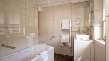 Ein modernes Badezimmer mit Badewanne, Toilette und Duschbereich.