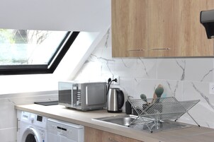 Una cocina moderna con lavadora integrada, tostadora y cafetera.