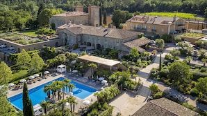 Una extensa propiedad con piscina, mobiliario exterior y viñedo.