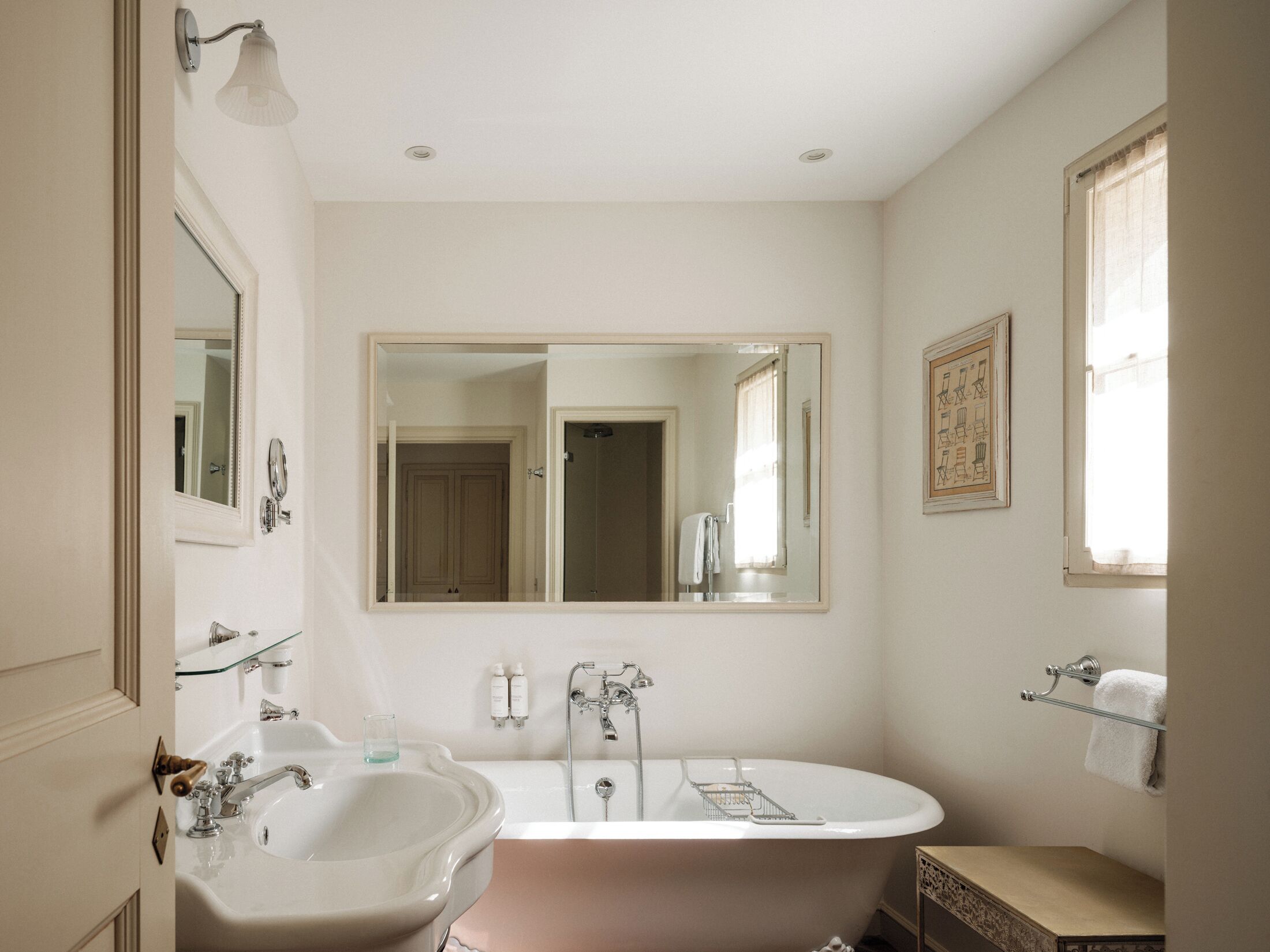 Un baño con lavamanos doble, bañera, espejo grande y ventana.