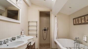 Une salle de bain avec deux lavabos, une baignoire, une douche et une fenêtre de toit.