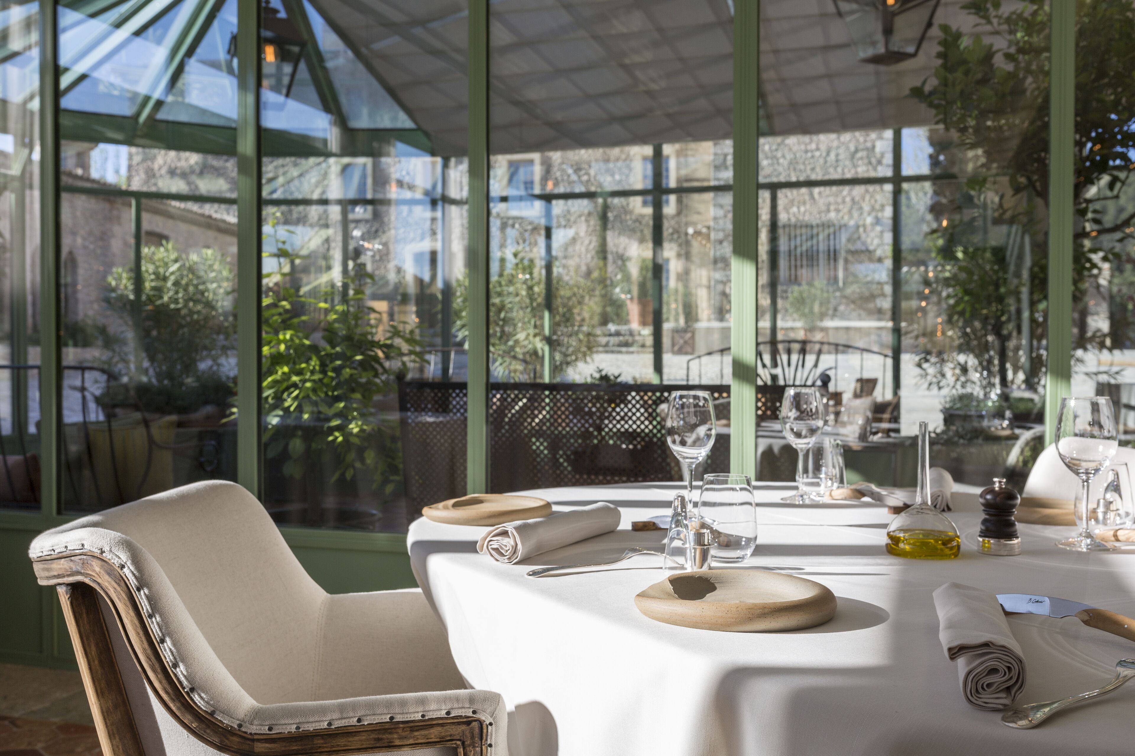 A table set for dining with a view of greenery outside.