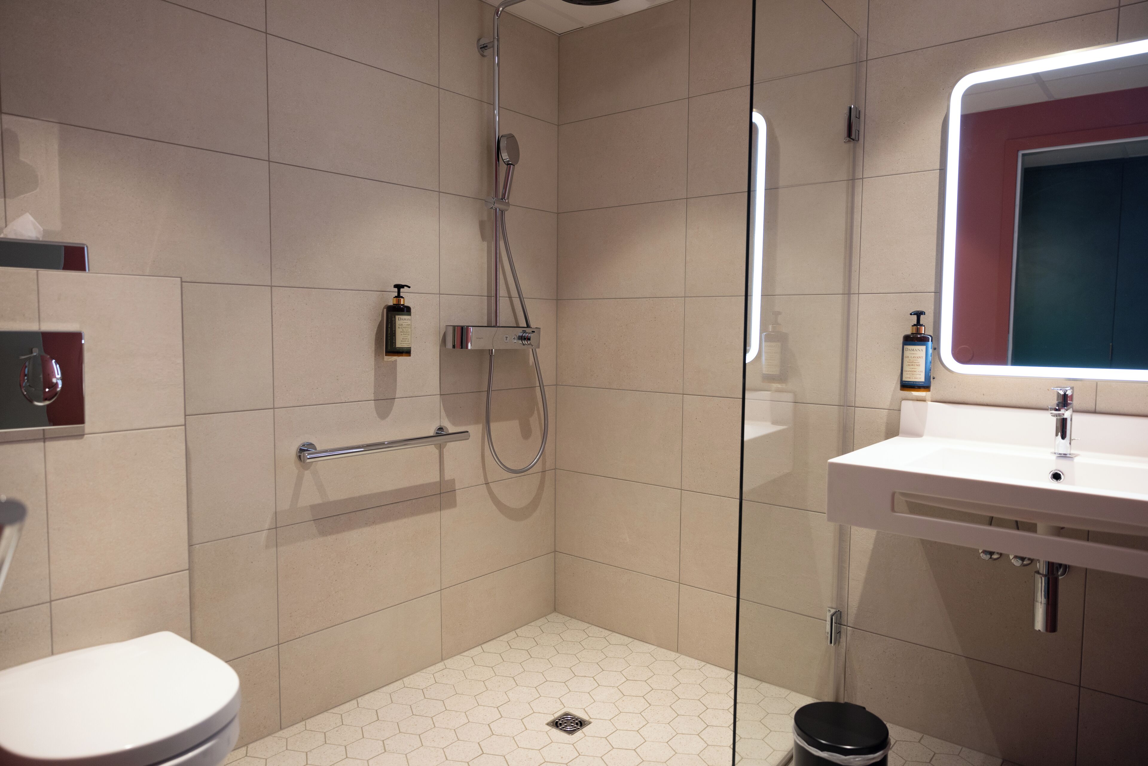 A modern bathroom with a shower, toilet, and sink.