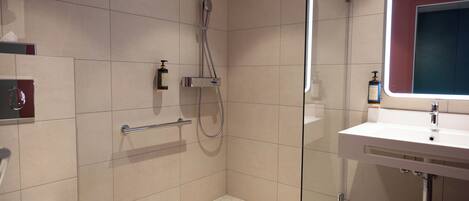A modern bathroom with a shower, toilet, and sink.