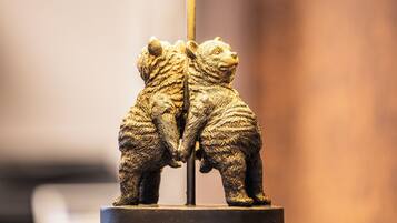 Une lampe dont le pied est orné d’une figurine d’ours et qui est surmontée d’un abat-jour jaune.
