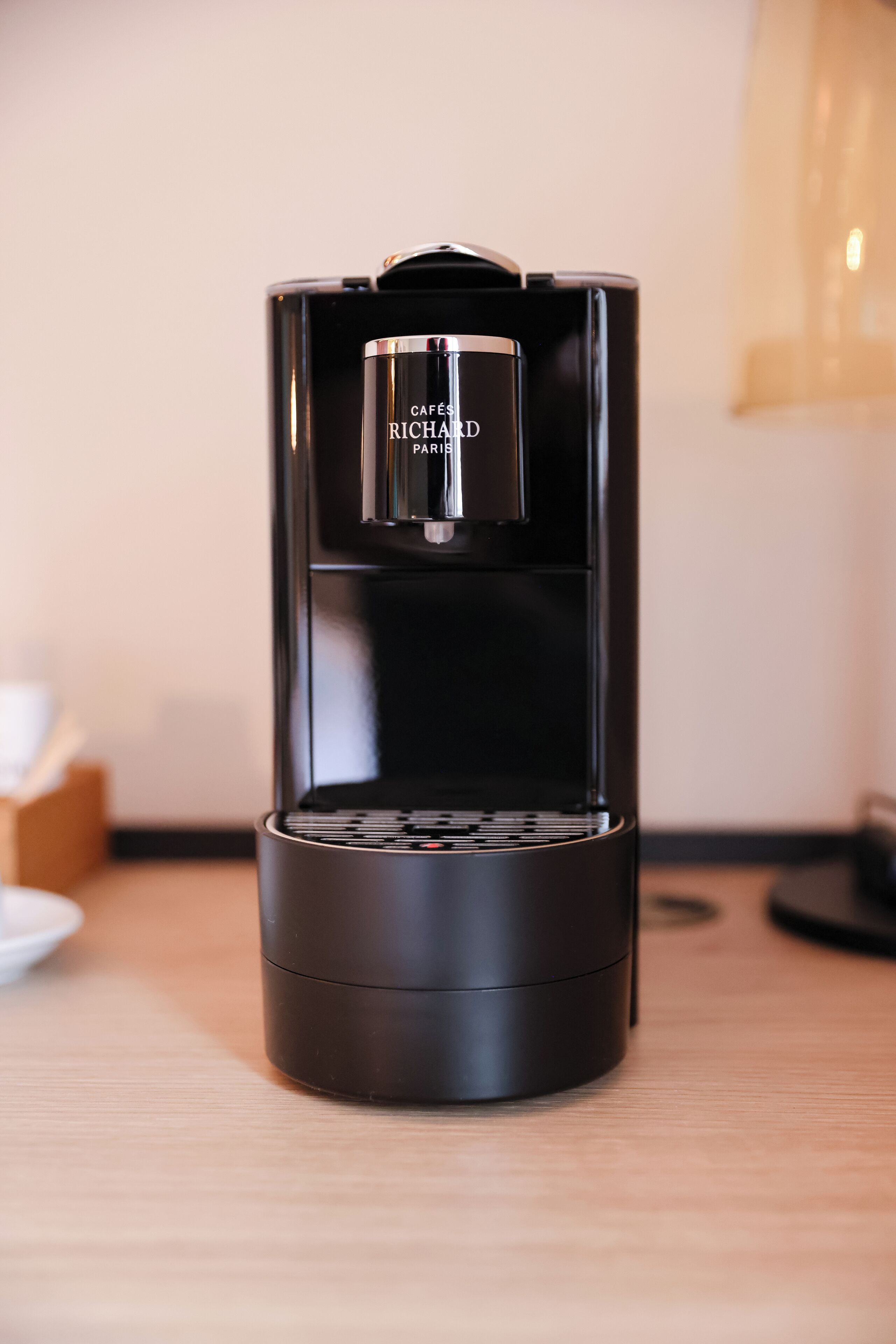 Una máquina de café espresso negra con depósito de agua transparente y un rótulo que dice 'Cafés Richard Paris'.