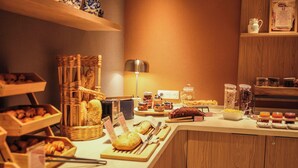A buffet setup with various food items and utensils.