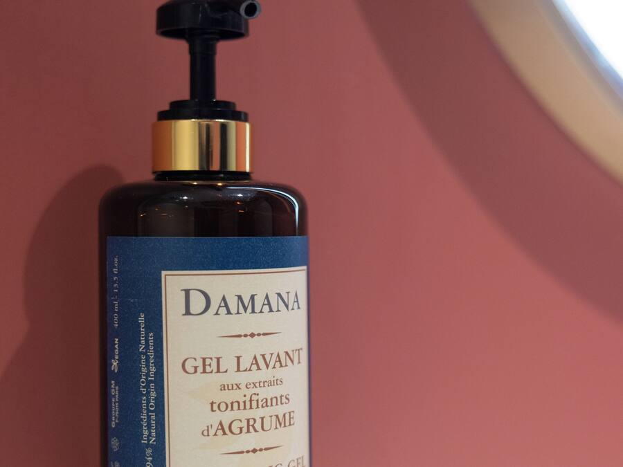 Una botella de gel limpiador Damana con extractos de cítricos.