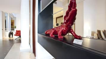 A red metal sculpture of a crocodile on a black counter with a sign identifying it as a piece by Richard Orlinski.