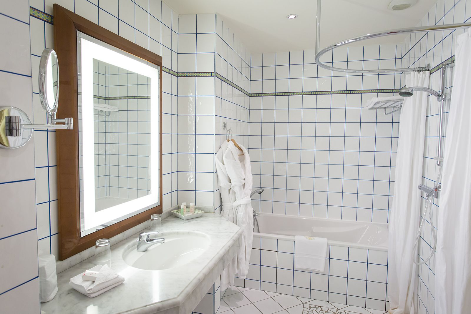 Un baño con un espejo grande, una bañera y una ducha.