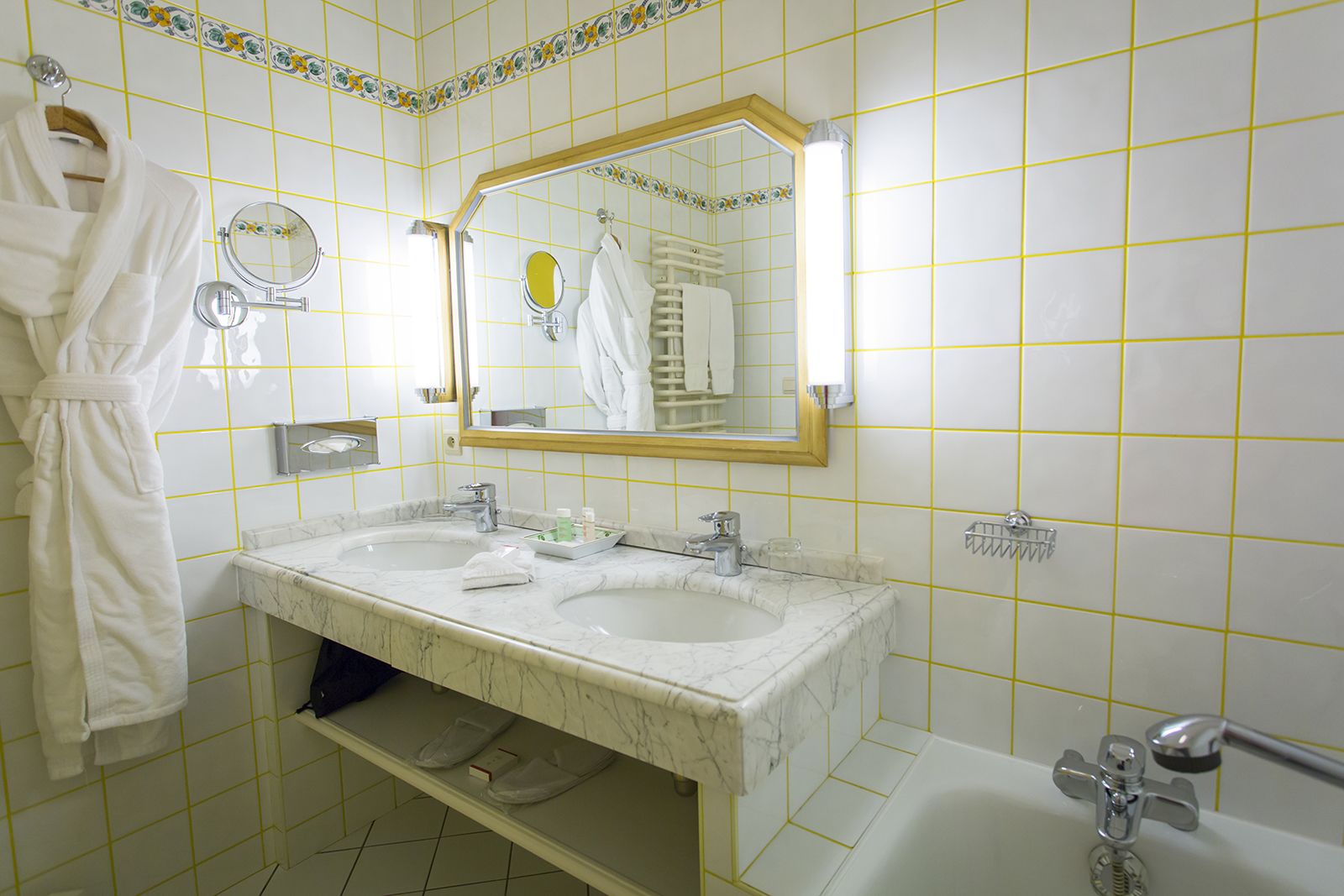 Un baño con dos lavamanos, una bañera y un espejo.