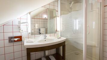 Ein Badezimmer mit Waschbecken, Spiegel und Dusche.