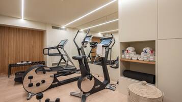 Ein modernes Fitnessstudio mit Laufbändern, Kurzhanteln und einer Trainingsbank.