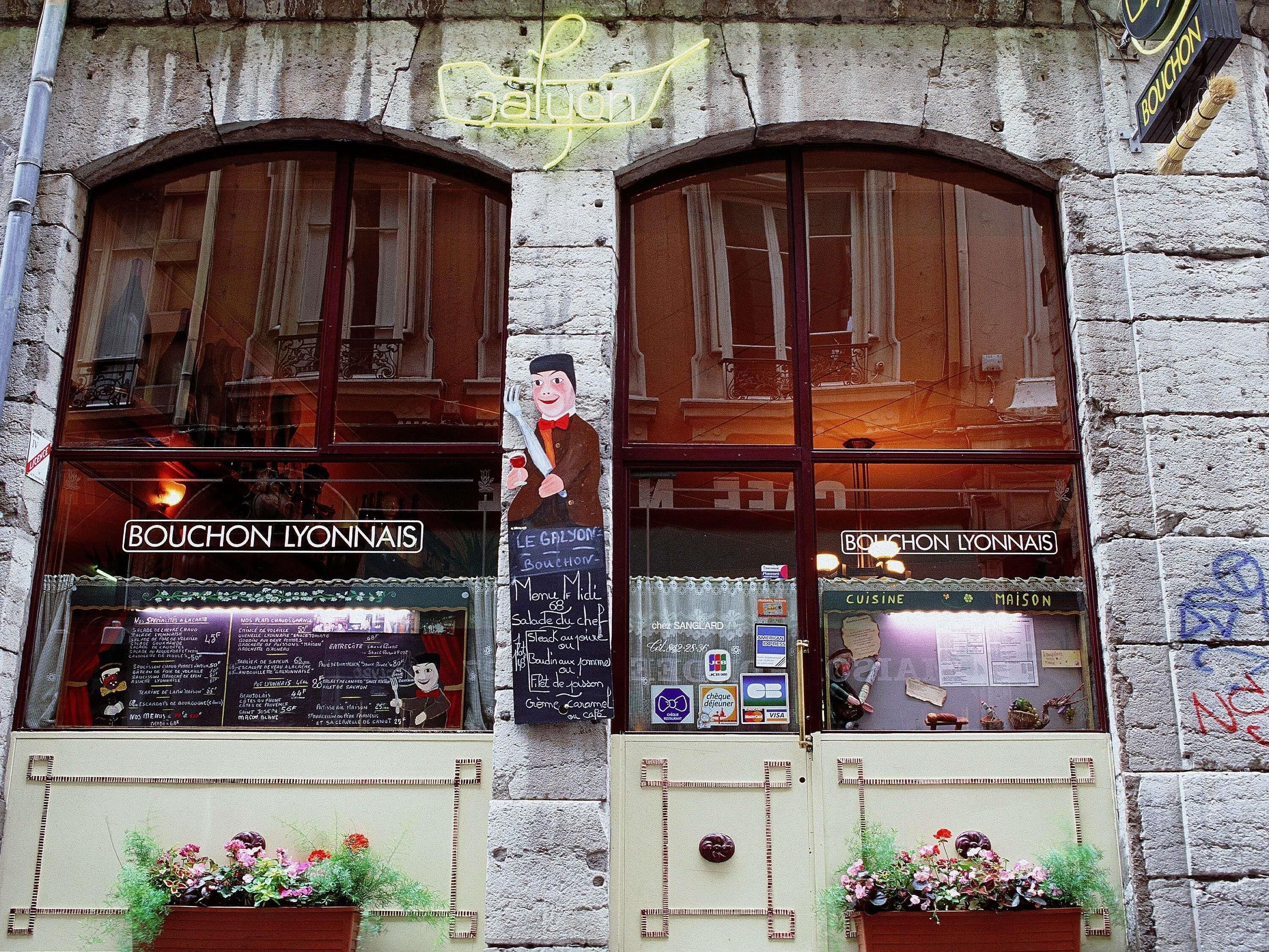 Ein Restaurant mit Bogenfenstern, einem Neonzeichen und einer Speisekarte.