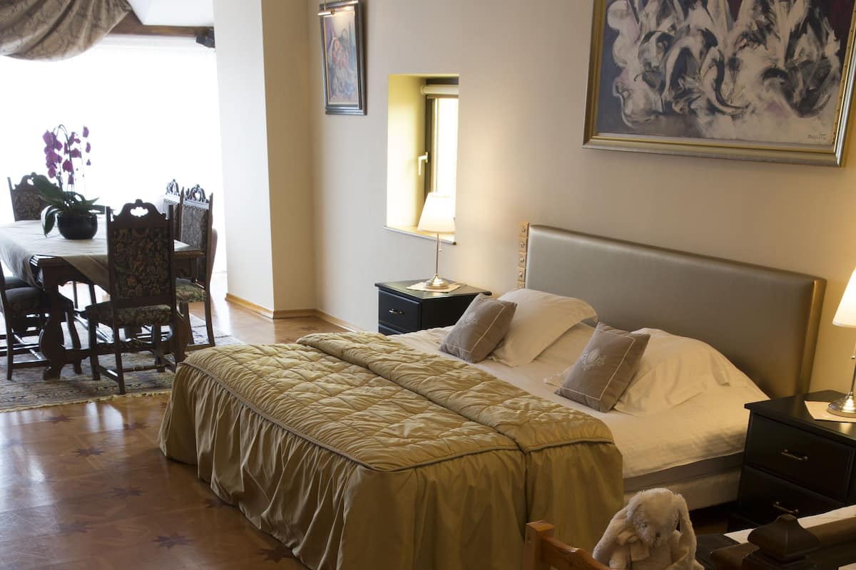 Une chambre d’hôtel avec un lit, une table de chevet, une lampe et une chaise.