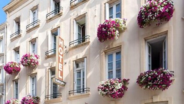 A hotel facade with multiple windows, some with hanging flower baskets. - Citotel Beausejour (Cherbourg-en-Cotentin)