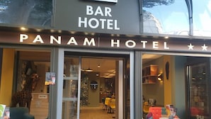The exterior of Panam Hotel with a bar area visible through the glass doors. - Panam Hotel (Paris)