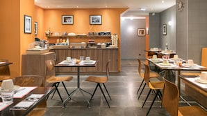 Un restaurante moderno con paredes de madera, una zona de bar central y varias mesas de comedor con sillas.