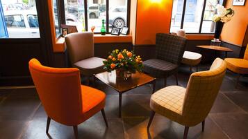 A seating area with a table, chairs, and a vase of flowers.