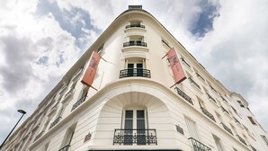Un edificio en esquina con un cartel que dice "HOTEL Bours".