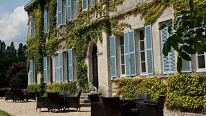 A historic building with a gravel patio and outdoor seating.