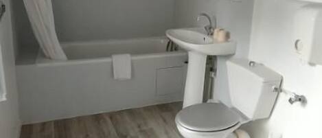 A bathroom with a bathtub, a sink, and a toilet.