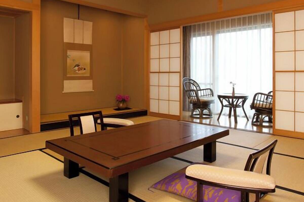 A traditional Japanese room with tatami flooring, a low table, and shoji screens.