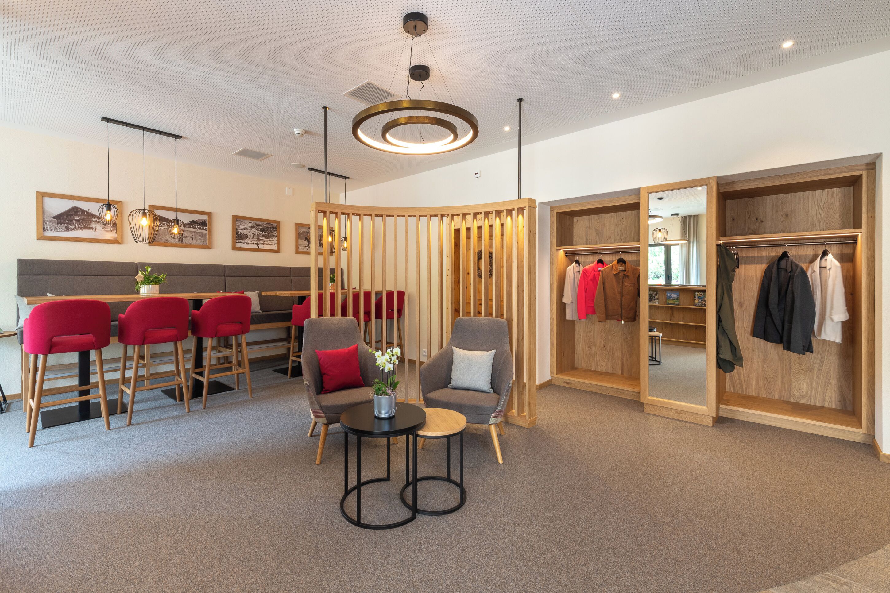 Un moderno vestíbulo de hotel con un área de descanso, un armario de madera y una percha para ropa.