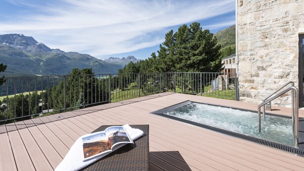 A wooden deck with a hot tub, overlooking a mountainous landscape. - Berghotel Randolins (St. Moritz)