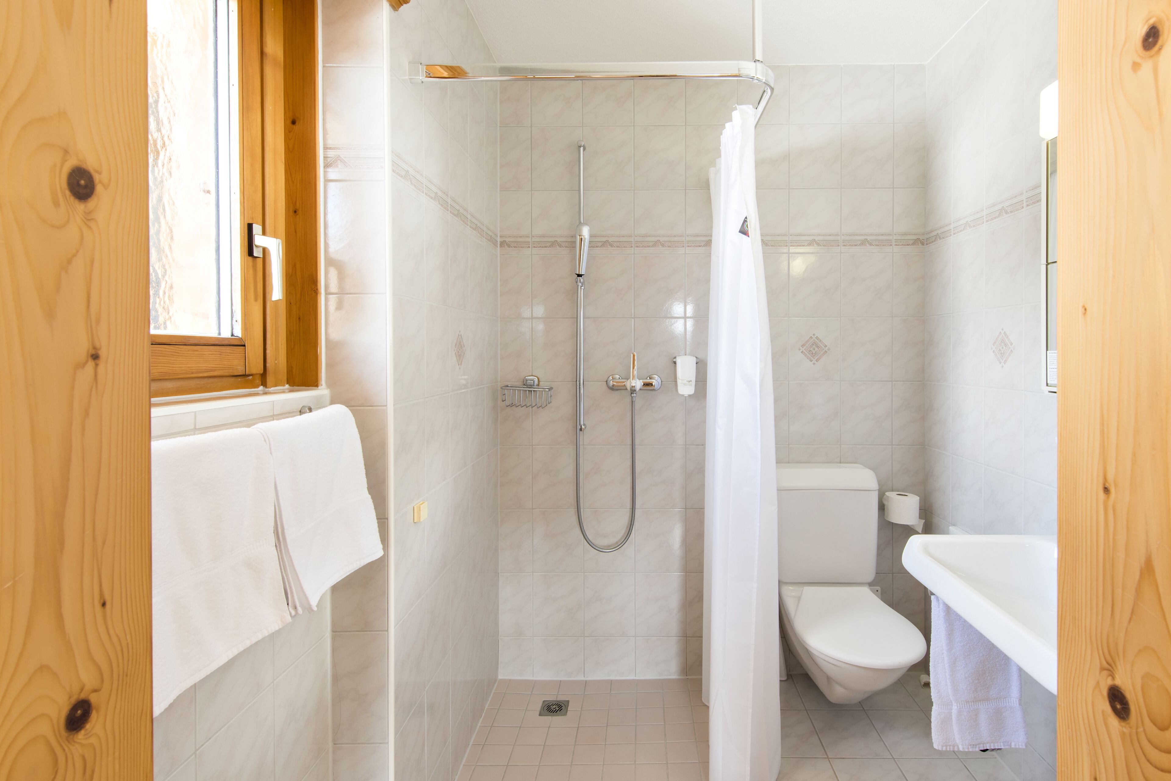 A bathroom with a shower, toilet, and sink.