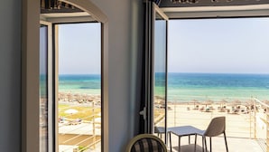 Un balcon avec vue sur la plage, une table et deux chaises.