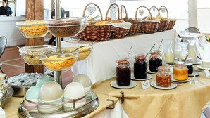 Une table de buffet proposant divers aliments, notamment des céréales, du pain et des boissons.
