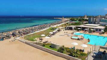 Un resort con playa, piscina y un molino.