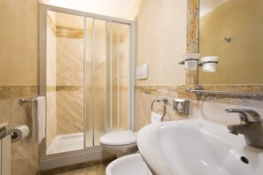 A bathroom with a glass shower enclosure, a white sink, and a toilet. - Hotel Teatro Pace (Rome)