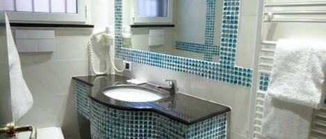 Un baño con inodoro, lavabo, bidé y espejo.
