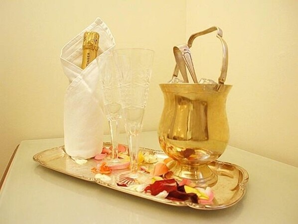 Ein Tablett mit einer Champagnerflasche, zwei Gläsern und einem goldfarbenen Eimer mit Henkel.