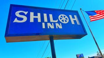 Een blauw bord met witte letters voor Shiloh Inn.