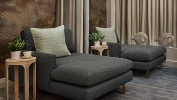 A modern living room with a sofa set, side tables, and decorative items.