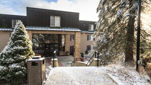 A building with a stone facade, large windows, and a snow-covered entrance.