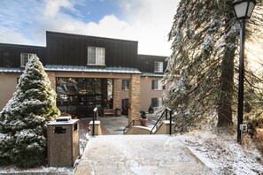 A building with a stone facade, large windows, and a snow-covered entrance.