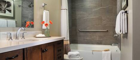 A modern bathroom with a shower, toilet, and sink.
