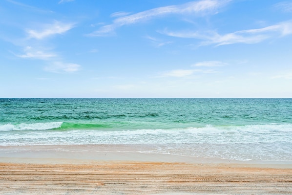 Una playa con olas y cielo despejado.